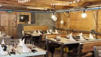 Fondue in the stable in the Sennästube Rustic barn from the inside, covered with tables and place settings