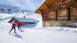 Two cross-country skiers on the Flumserberg in front of a hut