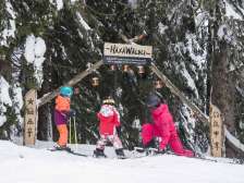 Two children and a woman at the entrance to the adventure slope on Flumserberg