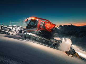 Red snow groomer on the Flumserberg at night