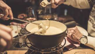 Fondue Swiss Heidi Hotel Several people enjoy a cheese fondue